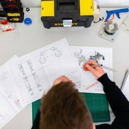 Mechanical Engineer Working on a Desk with technical drawings
