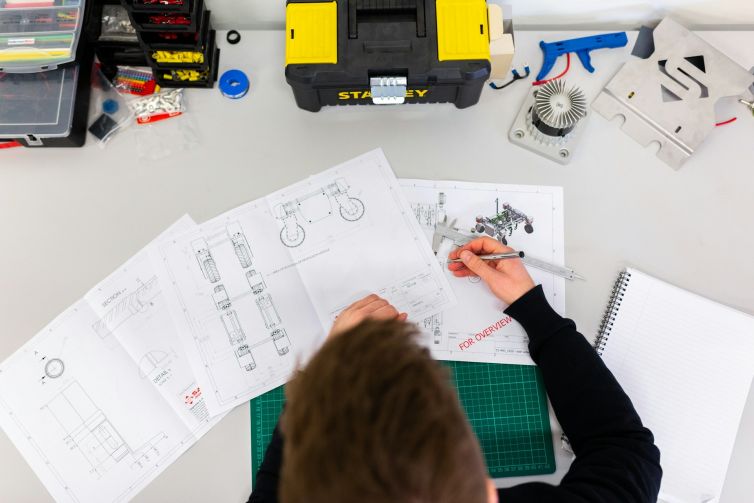 Mechanical Engineer Working on a Desk with technical drawings